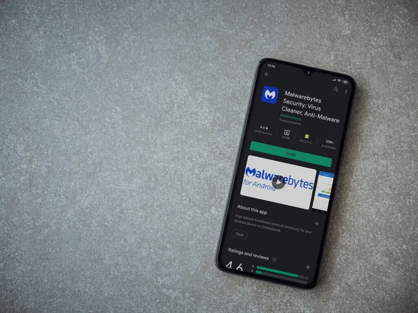 Lod, Israel - 8 Temmuz 2020: Malwarebytes Security uygulama oyun mağazası sayfası seramik taş zemin üzerinde siyah bir cep telefonu görüntüsü. Üst görünüm düzlüğü kopyalama alanı ile yatıyordu.