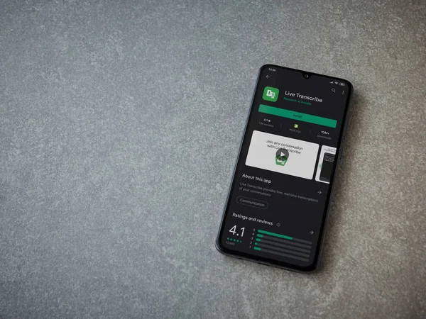 Lod, Israel - 8 Temmuz 2020: Seramik taş zemin üzerinde siyah bir cep telefonunun ekranında Live Transcribe uygulaması oyun mağazası sayfası. Üst görünüm düzlüğü kopyalama alanı ile yatıyordu.