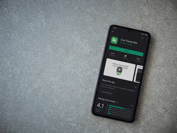 Lod, Israel - 8 Temmuz 2020: Seramik taş zemin üzerinde siyah bir cep telefonunun ekranında Live Transcribe uygulaması oyun mağazası sayfası. Üst görünüm düzlüğü kopyalama alanı ile yatıyordu.