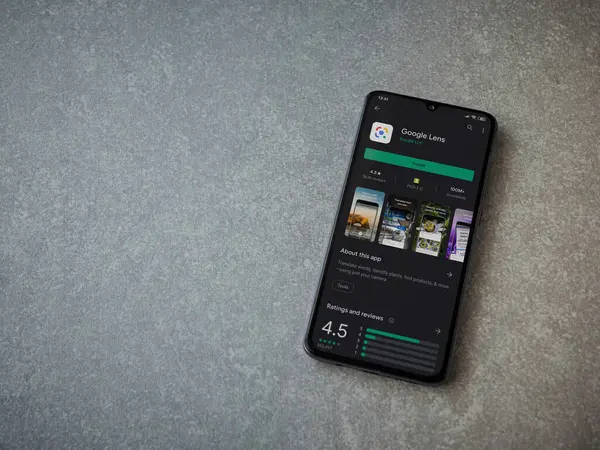 Lod, Israel - 8 Temmuz 2020: Google Lens uygulaması oyun mağazası sayfası seramik taş zemin üzerinde siyah bir cep telefonu görüntüsü. Üst görünüm düzlüğü kopyalama alanı ile yatıyordu.