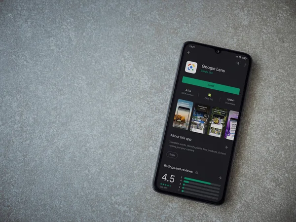 Lod, Israel - 8 Temmuz 2020: Google Lens uygulaması oyun mağazası sayfası seramik taş zemin üzerinde siyah bir cep telefonu görüntüsü. Üst görünüm düzlüğü kopyalama alanı ile yatıyordu.