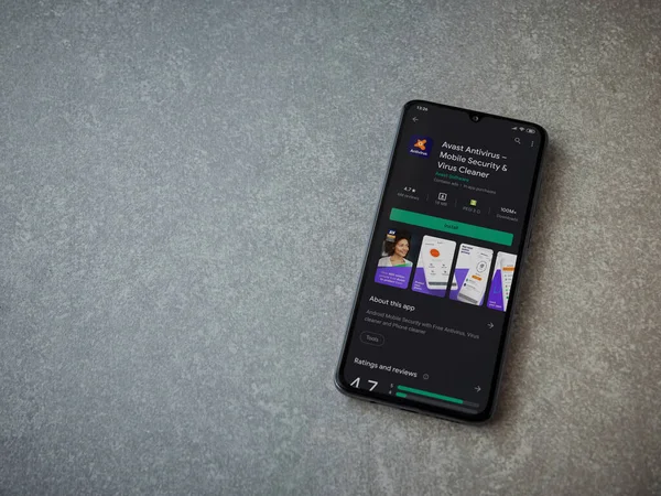 Lod, Israel - 8 Temmuz 2020: Seramik taş zemin üzerinde siyah bir cep telefonunun ekranında Antivirüs uygulaması oyun mağazası sayfası. Üst görünüm düzlüğü kopyalama alanı ile yatıyordu.