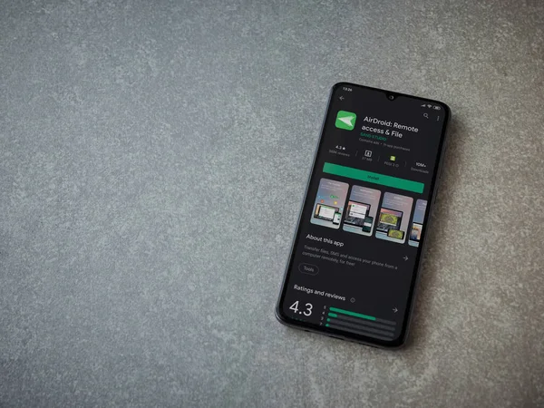 Lod, Israel - 8 Temmuz 2020: Airdroid uygulama oyun mağazası sayfası seramik taş zemin üzerinde siyah bir cep telefonu sergilenmektedir. Üst görünüm düzlüğü kopyalama alanı ile yatıyordu.