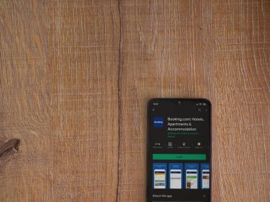 Lod, Israel - 8 Temmuz 2020: Booking.com uygulama oyun mağazası sayfası ahşap arka planda siyah bir cep telefonu görüntüsü. Üst görünüm düzlüğü kopyalama alanı ile yatıyordu.