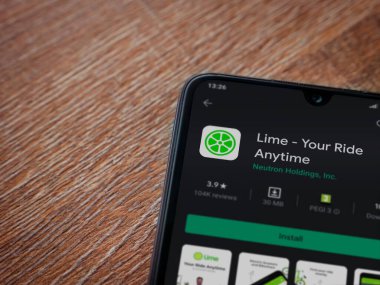 Lod, Israel - 8 Temmuz 2020: Lime app oyun mağazası sayfası ahşap arka planda siyah bir cep telefonunun ekranında. Üst görünüm düzlüğü kopyalama alanı ile yatıyordu.