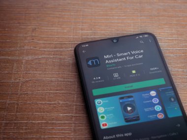 Lod, Israel - 8 Temmuz 2020: Miri uygulama oyun mağazası sayfası ahşap arka planda siyah bir cep telefonunun ekranında. Üst görünüm düzlüğü kopyalama alanı ile yatıyordu.