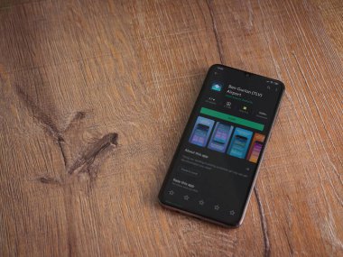 Lod, Israel - 8 Temmuz 2020: Ben Gurion Havalimanı uygulama oyun mağazası sayfası ahşap arka planda siyah bir cep telefonunun ekranında. Üst görünüm düzlüğü kopyalama alanı ile yatıyordu.