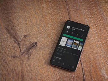 Lod, Israel - 8 Temmuz 2020: Hilton Honors uygulama oyun mağazası sayfası ahşap arka planda siyah bir cep telefonunun ekranında. Üst görünüm düzlüğü kopyalama alanı ile yatıyordu.