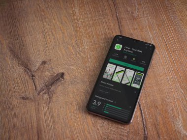 Lod, Israel - 8 Temmuz 2020: Lime app oyun mağazası sayfası ahşap arka planda siyah bir cep telefonunun ekranında. Üst görünüm düzlüğü kopyalama alanı ile yatıyordu.