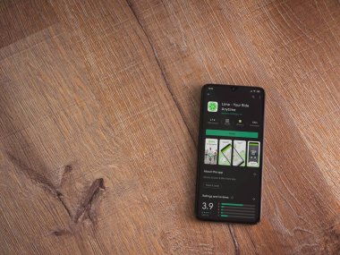 Lod, Israel - 8 Temmuz 2020: Lime app oyun mağazası sayfası ahşap arka planda siyah bir cep telefonunun ekranında. Üst görünüm düzlüğü kopyalama alanı ile yatıyordu.