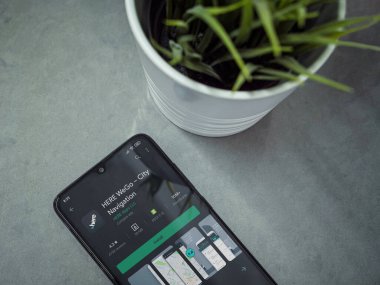 Lod, Israel - 8 Temmuz 2020: Modern minimalist ofis çalışma alanı ile siyah cep telefonu ile Here WeGo uygulama oyun sayfası mermer zemin üzerinde. Üst görünüm düzlüğü kopyalama alanı ile yatıyordu.