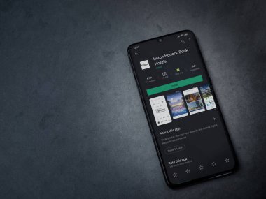 Lod, Israel - 8 Temmuz 2020: Hilton Honors uygulama oyun mağazası sayfası koyu mermer taşlı arka planda siyah bir cep telefonu ekranında. Üst görünüm düzlüğü kopyalama alanı ile yatıyordu.
