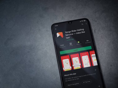 Lod, Israel - 8 Temmuz 2020: Yango Ride uygulaması oyun mağazası sayfası koyu mermer taşlı arka planda siyah bir cep telefonu ekranında. Üst görünüm düzlüğü kopyalama alanı ile yatıyordu.
