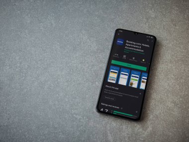 Lod, Israel - 8 Temmuz 2020: Booking.com uygulama oyun mağazası sayfasında seramik taş zemin üzerinde siyah bir cep telefonu görüntüsü. Üst görünüm düzlüğü kopyalama alanı ile yatıyordu.