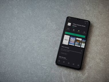 Lod, Israel - 8 Temmuz 2020: Hilton Honors uygulama oyun mağazası sayfası seramik taş zemin üzerinde siyah bir cep telefonu ekranında. Üst görünüm düzlüğü kopyalama alanı ile yatıyordu.