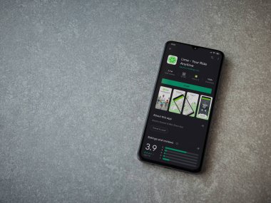 Lod, Israel - 8 Temmuz 2020: Lime app oyun mağazası sayfasında seramik taş zemin üzerinde siyah bir cep telefonu sergileniyor. Üst görünüm düzlüğü kopyalama alanı ile yatıyordu.
