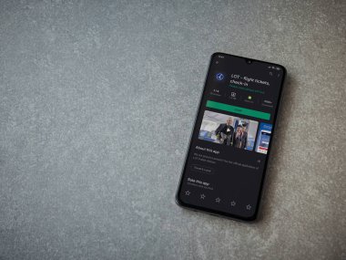 Lod, Israel - 8 Temmuz 2020: LOT uygulama oyun mağazası sayfası seramik taş zemin üzerinde siyah bir cep telefonu görüntüsü. Üst görünüm düzlüğü kopyalama alanı ile yatıyordu.