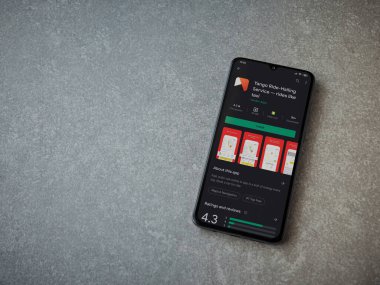 Lod, Israel - 8 Temmuz 2020: Yango Ride uygulaması oyun mağazası sayfası seramik taş zemin üzerinde siyah bir cep telefonu görüntüsü. Üst görünüm düzlüğü kopyalama alanı ile yatıyordu.