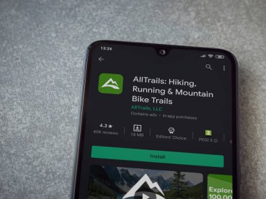 Lod, Israel - 8 Temmuz 2020: AllTrails uygulama oyun mağazası sayfası seramik taş zemin üzerinde siyah bir cep telefonu görüntüsü. Üst görünüm düzlüğü kopyalama alanı ile yatıyordu.