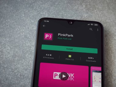 Lod, Israel - 8 Temmuz 2020: Pembe Park uygulama oyun mağazası sayfası seramik taş zemin üzerinde siyah bir cep telefonunun görüntüsü. Üst görünüm düzlüğü kopyalama alanı ile yatıyordu.