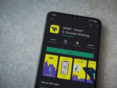 Lod, Israel - 8 Temmuz 2020: Rüzgâr uygulaması oyun mağazası sayfası seramik taş zemin üzerinde siyah bir cep telefonu görüntüsü. Üst görünüm düzlüğü kopyalama alanı ile yatıyordu.