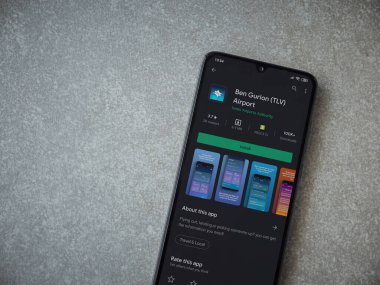 Lod, Israel - 8 Temmuz 2020: Ben Gurion Havaalanı uygulama oyun mağazası sayfası seramik taş zemin üzerinde siyah bir cep telefonu görüntüsü. Üst görünüm düzlüğü kopyalama alanı ile yatıyordu.
