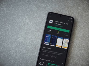 Lod, Israel - 8 Temmuz 2020: İsrail Demiryolları uygulama oyun mağazası sayfası seramik taş zemin üzerinde siyah bir cep telefonu ekranında. Üst görünüm düzlüğü kopyalama alanı ile yatıyordu.