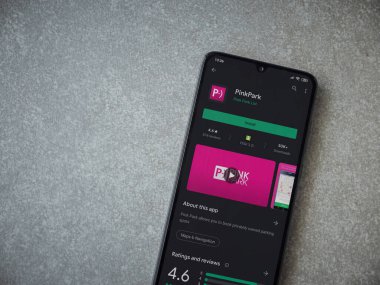 Lod, Israel - 8 Temmuz 2020: Pembe Park uygulama oyun mağazası sayfası seramik taş zemin üzerinde siyah bir cep telefonunun görüntüsü. Üst görünüm düzlüğü kopyalama alanı ile yatıyordu.