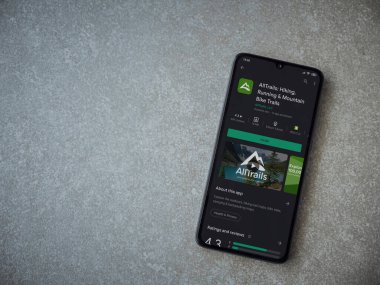 Lod, Israel - 8 Temmuz 2020: AllTrails uygulama oyun mağazası sayfası seramik taş zemin üzerinde siyah bir cep telefonu görüntüsü. Üst görünüm düzlüğü kopyalama alanı ile yatıyordu.