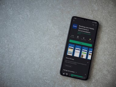 Lod, Israel - 8 Temmuz 2020: Booking.com uygulama oyun mağazası sayfasında seramik taş zemin üzerinde siyah bir cep telefonu görüntüsü. Üst görünüm düzlüğü kopyalama alanı ile yatıyordu.