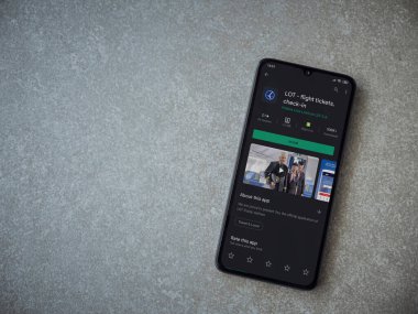 Lod, Israel - 8 Temmuz 2020: LOT uygulama oyun mağazası sayfası seramik taş zemin üzerinde siyah bir cep telefonu görüntüsü. Üst görünüm düzlüğü kopyalama alanı ile yatıyordu.