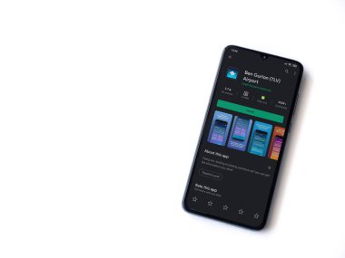 Lod, Israel - 8 Temmuz 2020: Ben Gurion Havaalanı uygulama oyun mağazası sayfası beyaz arkaplanda izole edilmiş siyah bir cep telefonu ekranında. Üst görünüm düzlüğü kopyalama alanı ile yatıyordu.