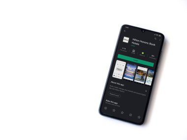 Lod, Israel - 8 Temmuz 2020: Hilton Honors uygulama oyun mağazası sayfası beyaz arka planda izole edilmiş siyah bir cep telefonu ekranında. Üst görünüm düzlüğü kopyalama alanı ile yatıyordu.