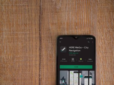 Lod, Israel - 8 Temmuz 2020: Here Weapp playshop sayfası ahşap arka planda siyah bir cep telefonunun ekranında. Üst görünüm düzlüğü kopyalama alanı ile yatıyordu.