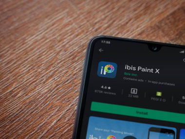 Lod, Israel - 8 Temmuz 2020: Ibis Paint X uygulama oyun mağazası sayfası, ahşap arka planda siyah bir cep telefonu görüntüsü. Üst görünüm düzlüğü kopyalama alanı ile yatıyordu.