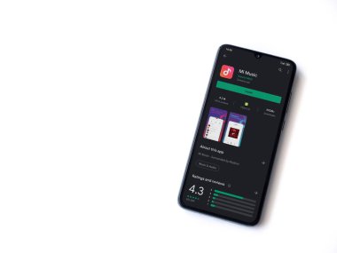 Lod, Israel - 8 Temmuz 2020: Mi Music uygulama oyun mağazası sayfası beyaz arkaplanda izole edilmiş siyah bir cep telefonu ekranında. Üst görünüm düzlüğü kopyalama alanı ile yatıyordu.