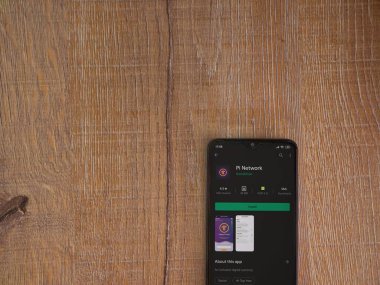 Lod, Israel - 8 Temmuz 2020: Pi Network uygulama oyun mağazası sayfası ahşap arka planda siyah bir cep telefonunun ekranında. Üst görünüm düzlüğü kopyalama alanı ile yatıyordu.