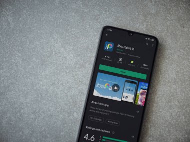 Lod, Israel - 8 Temmuz 2020: Ibis Paint X uygulama oyun mağazası sayfası seramik taş zemin üzerinde siyah bir cep telefonu görüntüsü. Üst görünüm düzlüğü kopyalama alanı ile yatıyordu.