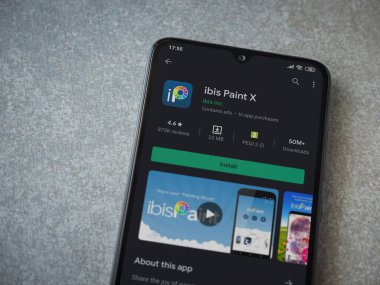 Lod, Israel - 8 Temmuz 2020: Ibis Paint X uygulama oyun mağazası sayfası seramik taş zemin üzerinde siyah bir cep telefonu görüntüsü. Üst görünüm düzlüğü kopyalama alanı ile yatıyordu.