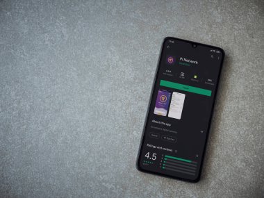 Lod, Israel - 8 Temmuz 2020: Pi Network uygulama oyun mağazası sayfası seramik taş zemin üzerinde siyah bir cep telefonu görüntüsü. Üst görünüm düzlüğü kopyalama alanı ile yatıyordu.