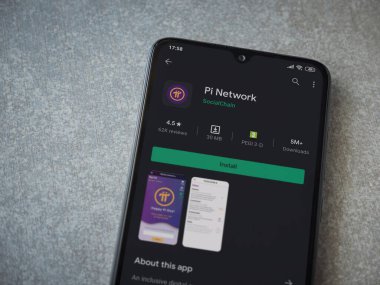 Lod, Israel - 8 Temmuz 2020: Pi Network uygulama oyun mağazası sayfası seramik taş zemin üzerinde siyah bir cep telefonu görüntüsü. Üst görünüm düzlüğü kopyalama alanı ile yatıyordu.