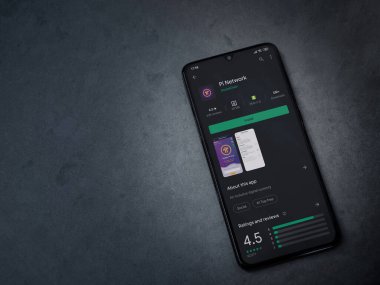 Lod, Israel - 8 Temmuz 2020: Pi Network uygulama oyun mağazası sayfası koyu mermer taştan arka planda siyah bir cep telefonunun ekranında. Üst görünüm düzlüğü kopyalama alanı ile yatıyordu.