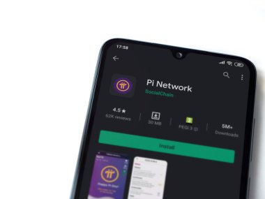 Lod, Israel - 8 Temmuz 2020: Pi Network uygulama oyun mağazası sayfası beyaz arkaplanda izole edilmiş siyah bir cep telefonu ekranında. Üst görünüm düzlüğü kopyalama alanı ile yatıyordu.