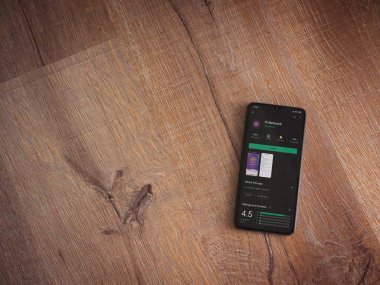 Lod, Israel - 8 Temmuz 2020: Pi Network uygulama oyun mağazası sayfası ahşap arka planda siyah bir cep telefonunun ekranında. Üst görünüm düzlüğü kopyalama alanı ile yatıyordu.