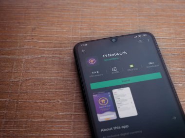 Lod, Israel - 8 Temmuz 2020: Pi Network uygulama oyun mağazası sayfası ahşap arka planda siyah bir cep telefonunun ekranında. Üst görünüm düzlüğü kopyalama alanı ile yatıyordu.