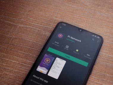 Lod, Israel - 8 Temmuz 2020: Pi Network uygulama oyun mağazası sayfası ahşap arka planda siyah bir cep telefonunun ekranında. Üst görünüm düzlüğü kopyalama alanı ile yatıyordu.