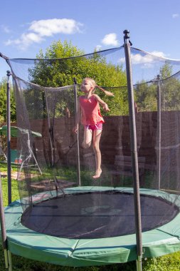 koruyucu ağ arkasında bir trambolin üzerinde atlama kız