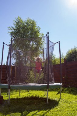 koruyucu ağ arkasında bir trambolin üzerinde atlama kız