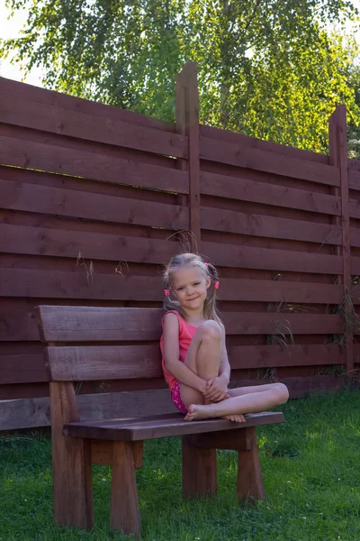 Menina pensativa sentado no banco de madeira — Fotografia de Stock