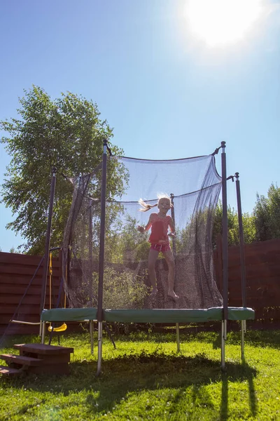 koruyucu ağ arkasında bir trambolin üzerinde atlama kız